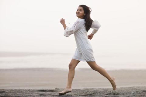 USA, Montana, young woman jogging on beach. Photo : Noah Clayton