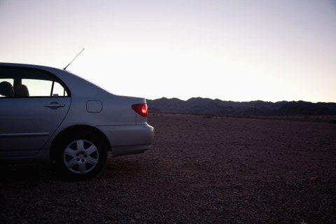 USA, Nevada, car on desert road at dusk. Photo : Johannes Kroemer
