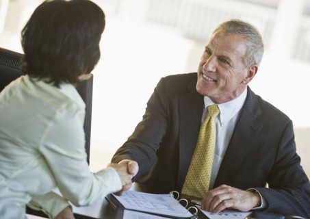 Businesswoman and businessman shaking hands.