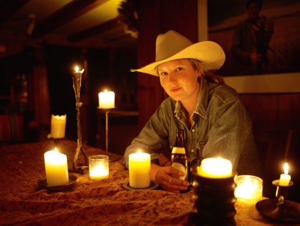 USA, Colorado, Portrait of cowgirl sitting at table with candles. Photo : John Kelly