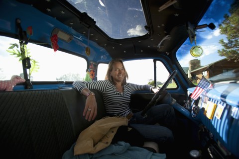 USA, Colorado, Carbondale, Smiling mature woman sitting in vintage car, portrait. Photo : Noah