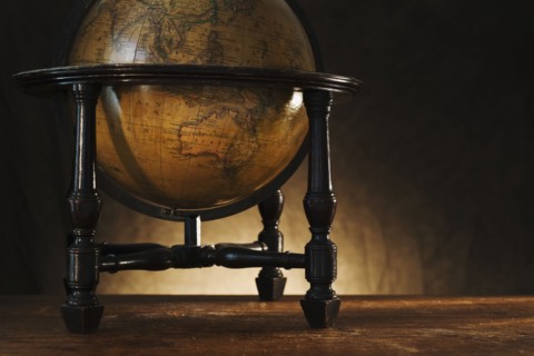 Close up of antique globe on table.