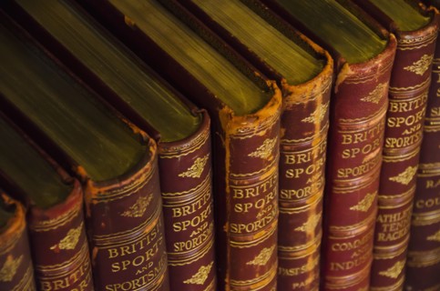 Close up of antique books on shelves.