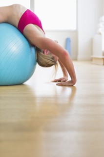 Woman exercising on fitness ball. Photo : Daniel Grill