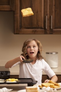 Girl (10-11) flipping toast in kitchen. Photo : Mike Kemp