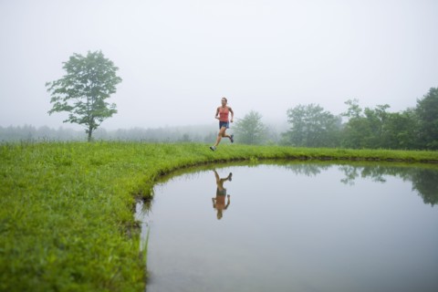 USA, Vermont, Landgrove, Woman jogging by lake. Photo : Noah Clayton