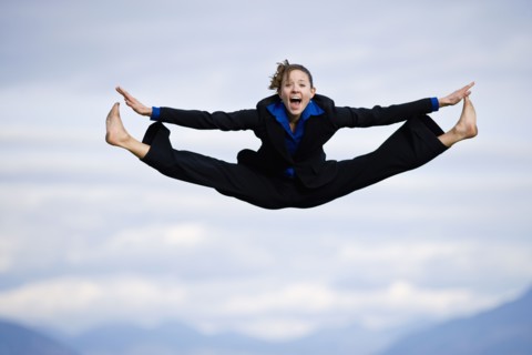 Businessman mid-air doing splits. Photo : Noah Clayton