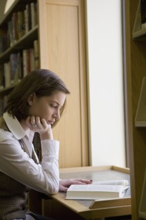 USA, New Jersey, female student reading book in library. Photo : Chris Hackett
