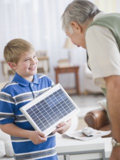 Grandson (8-9) showing solar panel to Grandfather. Photo : Jamie Grill Photography