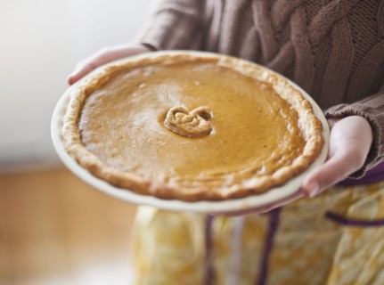 Close up of woman holding pumpkin pie.