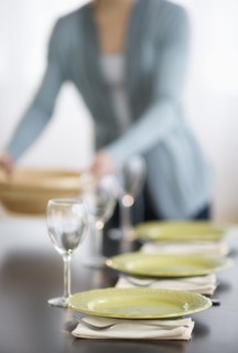 Young woman setting table.