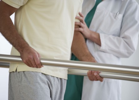 Close-up of physiotherapist assisting patient with recovery exercise.