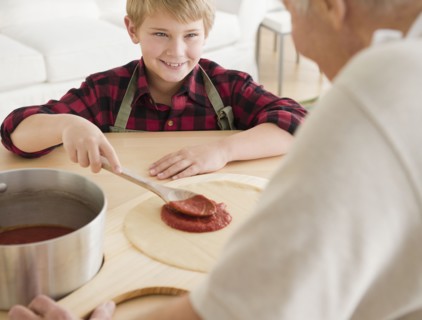 Grandfather and grandson (8-9) preparing pizza. Photo : Jamie Grill Photography