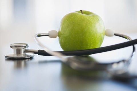Green apple with stethoscope.