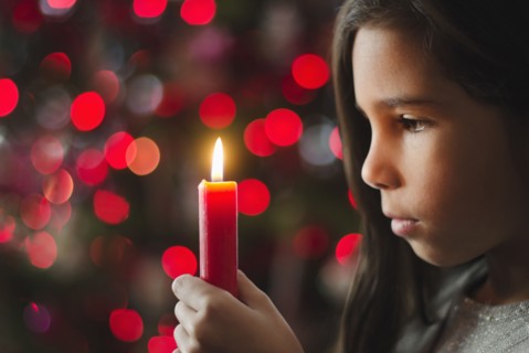 Girl (8-9) holding candle.