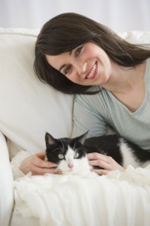 Portrait of woman with cat on sofa.