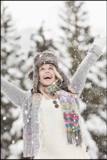 USA, Utah, Salt Lake City, young woman in winter clothing throwing snow in air. Photo : Mike Kemp