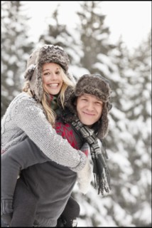 USA, Utah, Salt Lake City, man giving young woman piggy back ride in snow. Photo : Mike Kemp