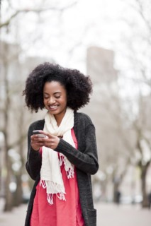 USA, Washington State, Seattle, Cheerful young woman text messaging. Photo : Take A Pix Media