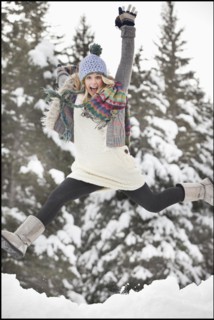 USA, Utah, Salt Lake City, portrait of young woman in winter clothing leaping. Photo : Mike Kemp