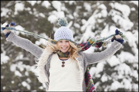 USA, Utah, Salt Lake City, portrait of young woman in winter clothing pulling hat strings. Photo :
