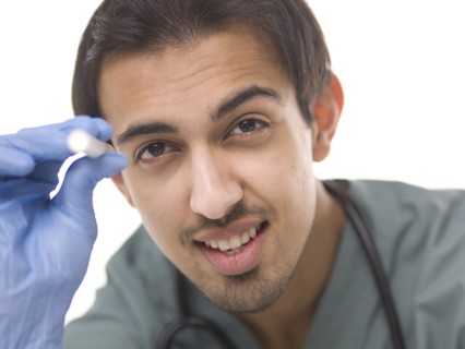 Young surgeon holding small torch. Photo : Dan Bannister