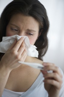 Woman with flu blowing nose.