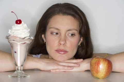 Woman choosing between ice cream and apple.