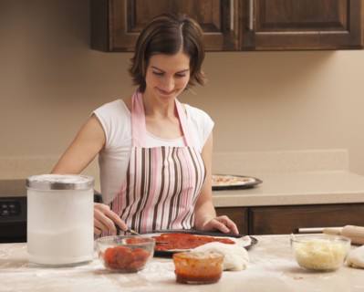 Woman preparing pizza. Photo : Mike Kemp