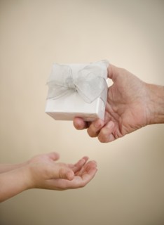 Close up of hands of grandfather and grandson (8-9) with gift. Photo : Jamie Grill Photography