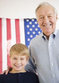Portrait of grandfather with grandson (8-9) with American flag. Photo : Jamie Grill Photography