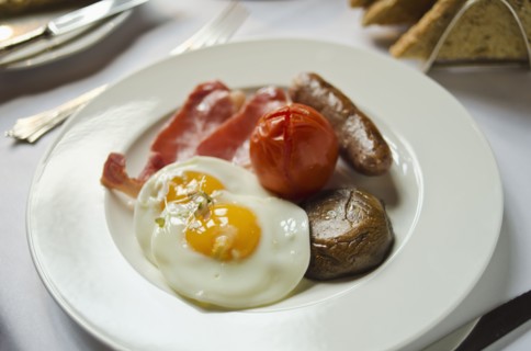 Plate with English breakfast on table.