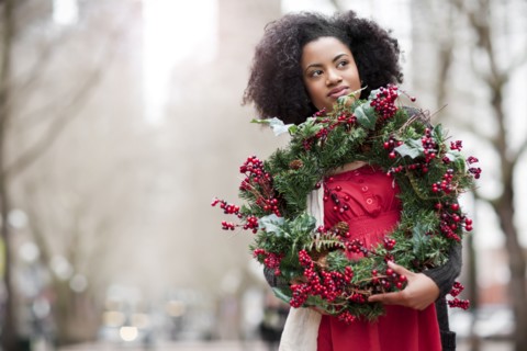 USA, Washington State, Seattle, Young woman holding christmas wreath. Photo : Take A Pix Media