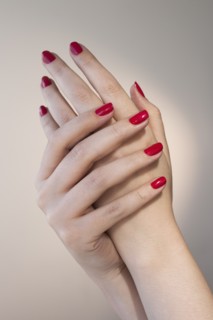 Close up of woman's hands with red nail polish.