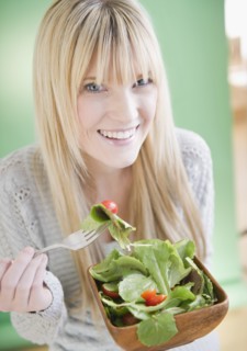 Young woman eating salad. Photo : Jamie Grill Photography