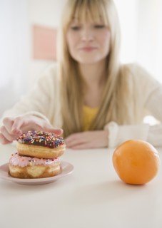 Woman reaching for donut. Photo: Jamie Grill Photography