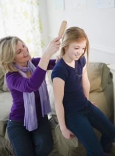 Mother brushing daughter's (10-11) hair. Photo : Jamie Grill Photography