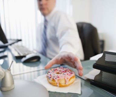 Businessman reaching for donut. Photo: Jamie Grill Photography