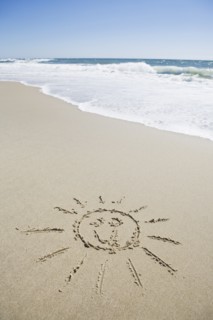 USA, Massachusetts, Sun face drawn on sandy beach. Photo : Chris Hackett