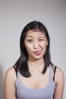 Young woman sticking out tongue. Photo : Winslow Productions