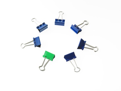 Blue and green bulldog clips on white background. Photo: David Arky