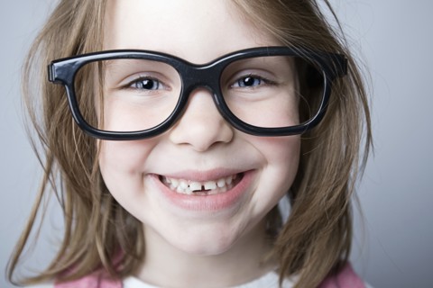 Studio portrait of girl (6-7) wearing big glasses. Photo : Justin Paget