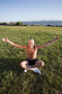 USA, California, Berkeley, Senior man sitting cross-legged on grass. Photo : Noah Clayton