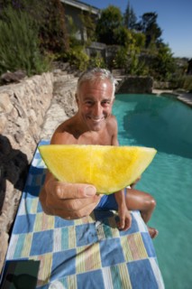 USA, California, Oakland, Senior man relaxing at swimming pool. Photo : Noah Clayton