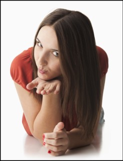 Studio portrait of young woman blowing a kiss. Photo: Mike Kemp