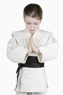 Studio portrait of girl (6-7) wearing karate uniform. Photo : Justin Paget