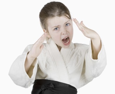 Studio portrait of girl (6-7) wearing karate uniform. Photo : Justin Paget