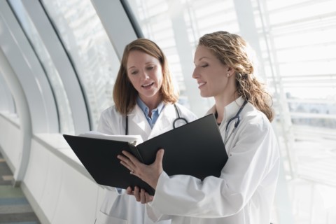 Two female doctors reading record. Photo : Mark Edward Atkinson