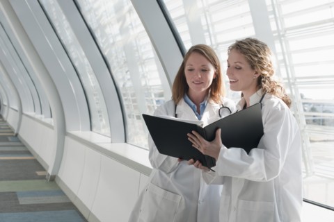 Two female doctors reading record. Photo : Mark Edward Atkinson