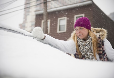 USA, New Jersey, Jersey City, woman removing snow from wind shield. Photo: Jamie Grill Photography